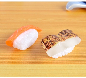 Detailed macro view of realistic PVC salmon and seared fish sushi models on a wooden table