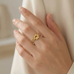 Detailed view of a gold woven mesh ring featuring a hollow star charm on finger
