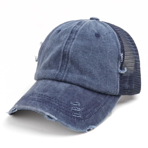 Detail of distressed dark blue washed cotton baseball cap with breathable mesh and ripped brim