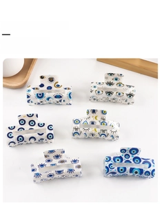 Six assorted Evil Eye patterned PVC hair claw clips for women displayed on white background