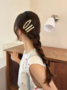 Detail view of cream acetate hair clips set worn as side barrettes for styling