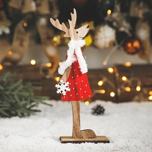Figurine de renne de Noël en bois avec robe rouge à pois et écharpe blanche sur neige