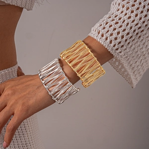 Macro shot of minimalist golden and silver woven wire wide open cuff bracelets