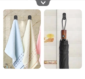 Close-up of black multifunctional wall hooks holding a towel and umbrella on tile
