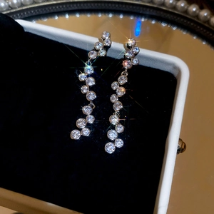 Macro shot of silver tassel earrings with round cubic zirconia in a jewelry box