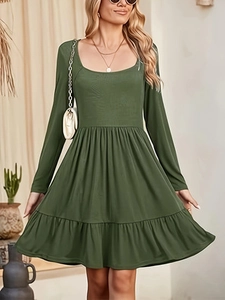 Close-up of dark green long sleeve dress featuring ruffle hem and textured fabric detail