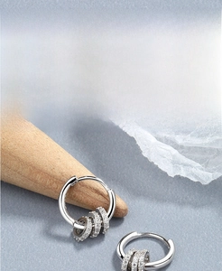 Detail of S925 sterling silver hoop earrings with triple rows of zircon stone accents
