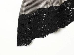 Detail of houndstooth fabric with black lace trim on sleeveless stand collar top