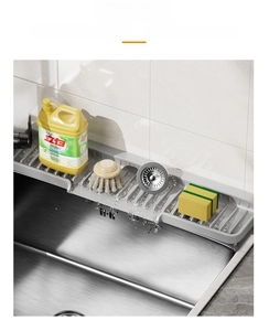 Detail view of the gray silicone sink tray showing drainage slots and water runoff slope