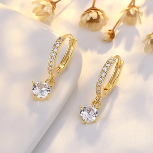 Elegant gold drop earrings with round white zircon pendants in a minimalist chic style