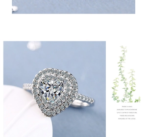 Macro shot of silver heart-shaped ring with double halo and pavé set sparkling zircon