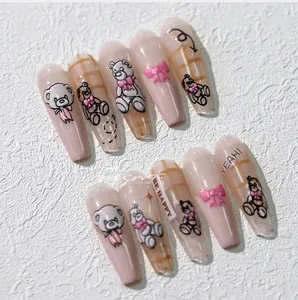 Detailed view of 3D bear and bow nail art stickers in nude pink and plaid design
