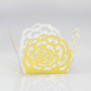 Detailed laser-cut yellow paper cupcake wrapper with intricate rose pattern