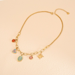 Gold chain necklace with colorful heart, cat eye stone, and star charms on beige background