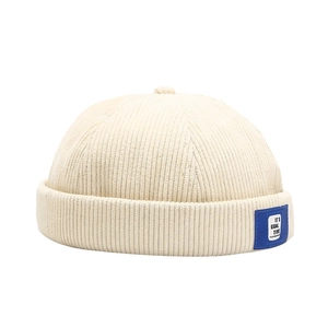 Retro corduroy docker cap in beige featuring a blue side label with balanced top view