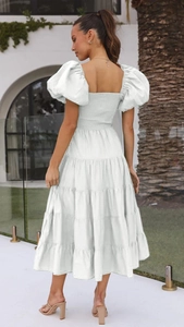 Detail of white puff sleeve maxi dress showing backless elastic waist and tiered skirt