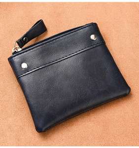 Detail view of the navy blue coin purse featuring premium leather grain and metal rivets