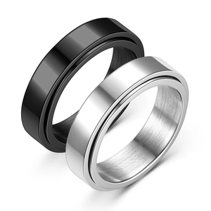 Macro detail of black and silver stainless steel spinner rings with brushed metal texture