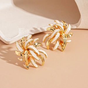 Macro shot of gold-plated metal flower stud earrings with white enamel petals