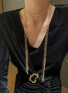 Close-up of a gold mesh woven necklace featuring elegant long tassel pendant details