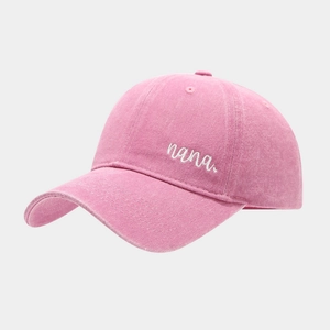 Detailed close-up of pink washed cotton baseball cap featuring white nana embroidery