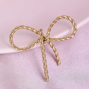 Macro view of gold 304 stainless steel bow pendant with twisted rope texture