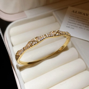 Macro detail of gold-plated quilted bangle with sparkling cubic zirconia pavé setting