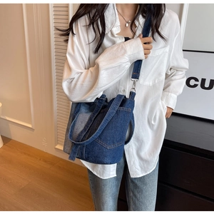 Detail showing blue denim patchwork crossbody bucket bag with pocket on white shirt model