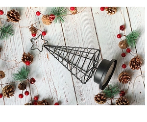 Black iron LED Christmas tree lamp with star topper on white wood background