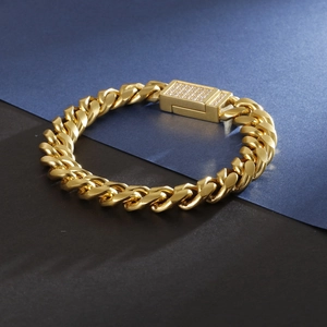 Gros plan sur bracelet gourmette doré avec fermoir serti de diamants sur fond bicolore chic