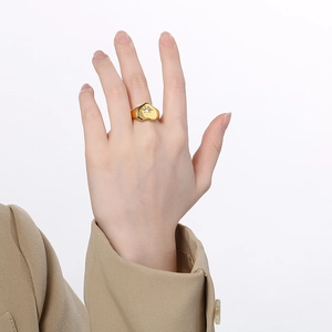 Detail eines goldenen Herzrings mit funkelndem Sternen-Diamanten am Finger