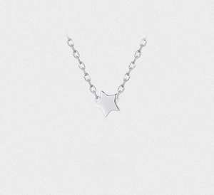 Macro shot of minimalist 925 sterling silver star pendant with polished mirror finish