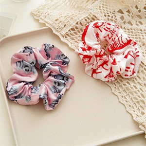 Detail of satin Halloween scrunchies featuring spooky ghost and bloody handprint patterns