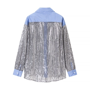 Détail de la chemise à sequins avec rayures bleues et blanches sur les poignets