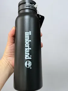 Macro shot of matte black insulated water bottle with printed logo and magnetic ring lid