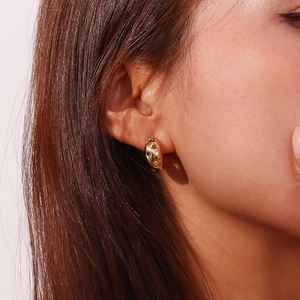 Close-up of 18K gold-plated hoop earring with colorful zircon stars and moon inlays