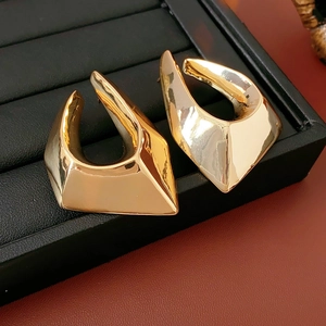 Detailed view of gold plated irregular triangle earrings on a black jewelry stand