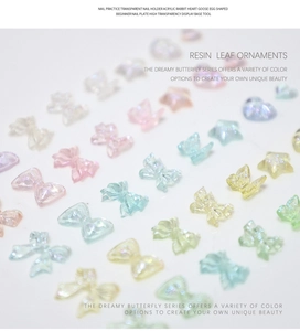 Macro shot of colorful resin bow and star nail art charms with iridescent glitter effects