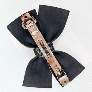 Elegant black bow hair clip with white rhinestones and a premium metal spring fastener
