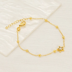 Macro shot of gold-plated titanium bracelet with flower pendant and clear zircon inlay