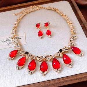 Detailed view of vintage gold jewelry set with red teardrop stones and rhinestones