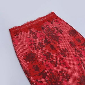 Gros plan détaillé de la jupe rouge à fleurs avec bordure en dentelle et motifs à la taille