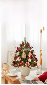 Mini tabletop Christmas tree with red bows, pine cones, and LED lights in a white metal bucket