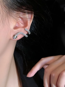 Gros plan sur le protège-oreille serpent en argent avec zircons et yeux émeraude