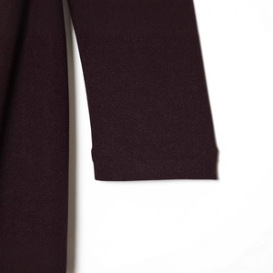 Robe moulante à col en V et manches longues violet foncé montrant la texture du tissu