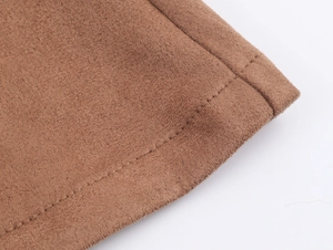 Macro detail of brown suede fabric featuring precise double stitching on the seam