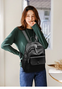 Model wearing a black textured leather backpack with multi-zipper pockets for daily commute