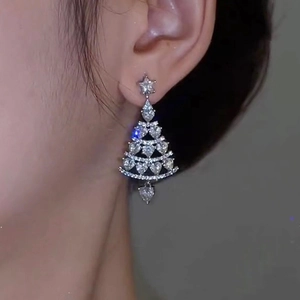 Detailed close-up of a zircon-inlaid Christmas tree earring with a heart-shaped pendant