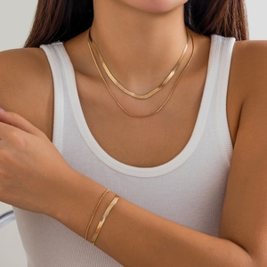 Golden snake chain necklace and bracelet set featuring a layered punk geometric design
