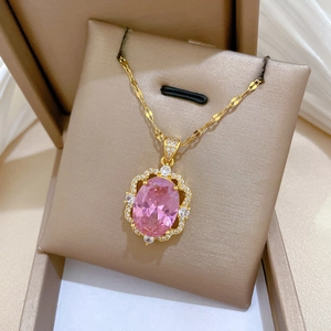 Detailed close-up of a pink oval gemstone necklace with sparkling diamond-set halo in a box